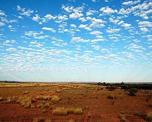 Verlaten landschap van centraal Australia met wolkjes en zonnestralen