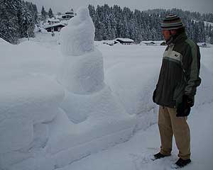 Hannes bij de sneeuwman in Fieberbrunn na een nachtje sneeuwen