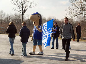 De mascotte van FC Schalke 04 wacht de supporters op buiten het stadion