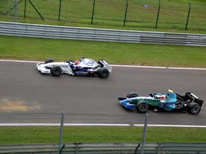 Rubens Barrichello met een inhaalmanoevre op de rechte strook gaat Robert Kubica voorbij.